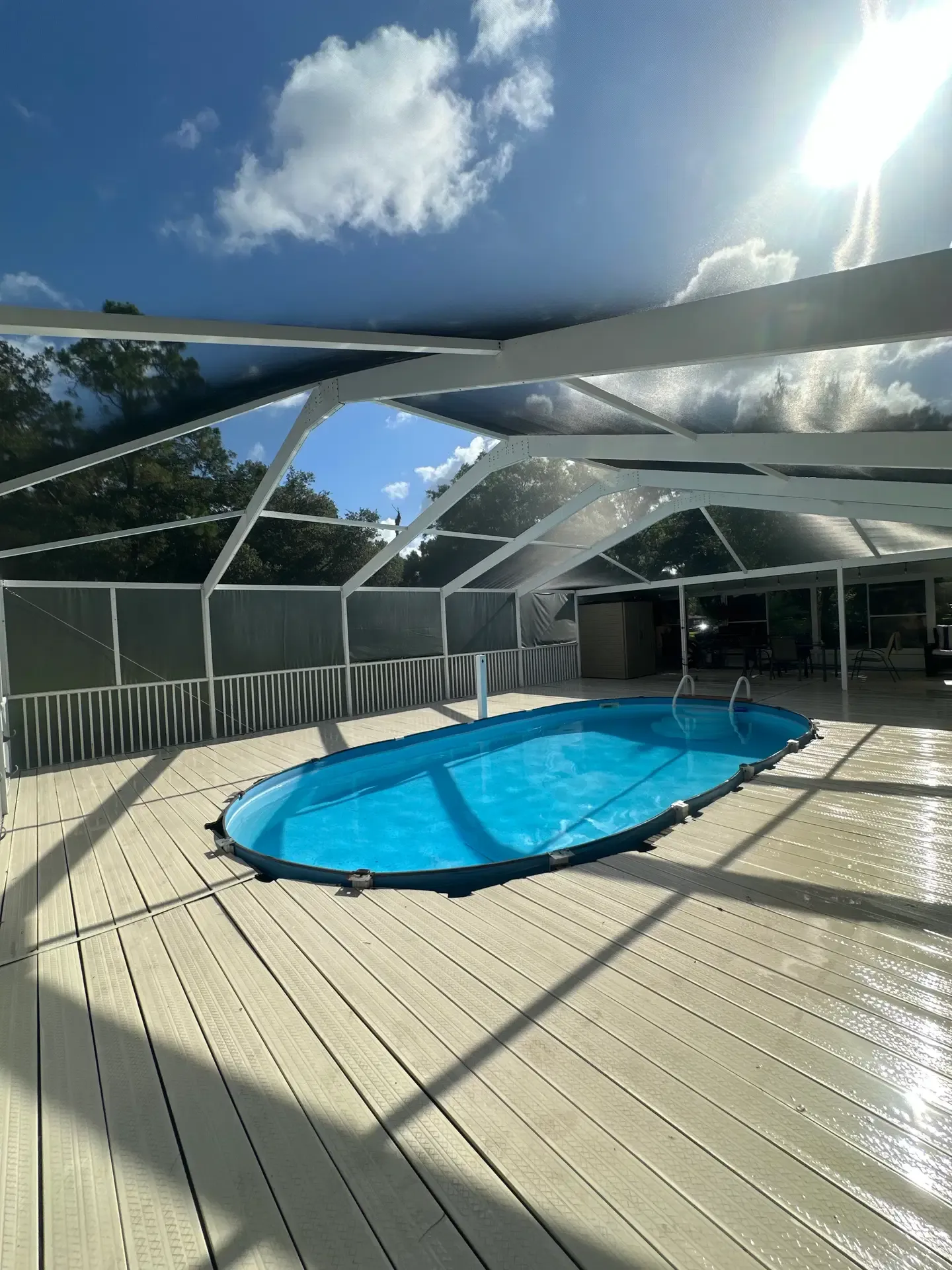 A bright, freshly rescreened pool enclosure with taut panels and clean aluminum lines